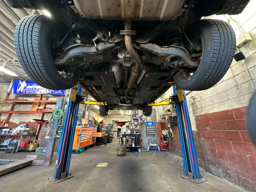 Car raised for underbody service at Ronnie's Automotive in Billerica, MA.