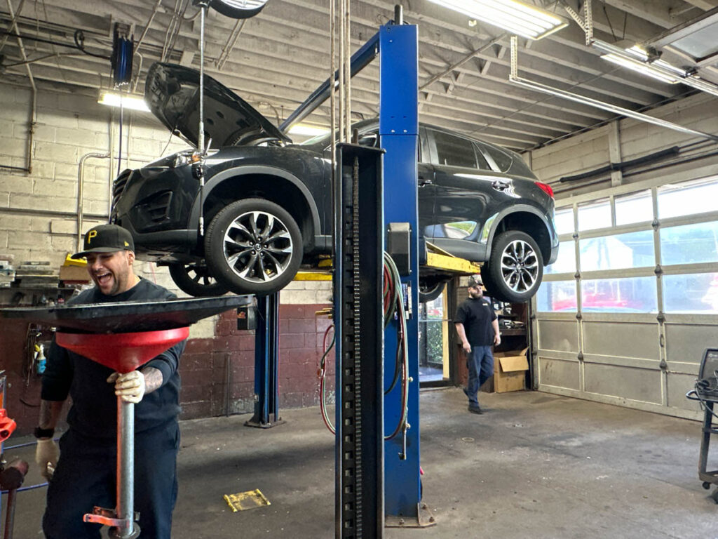 Black SUV raised for underbody service at Ronnie's Automotive in Billerica, MA.