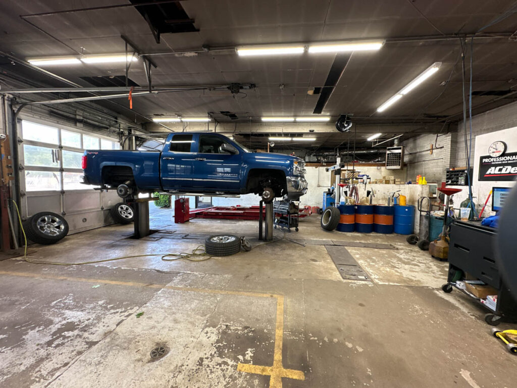 View of the Workspace at Ronnie's Automotive with Blue Truck raised for Service. Located in Billerica, MA.